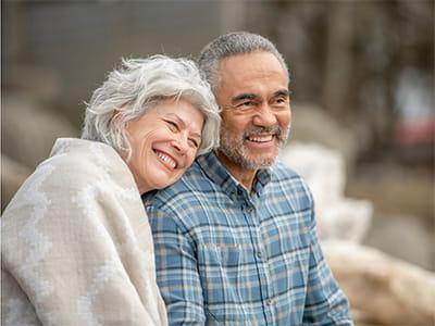 older couple smiling and looking off to the distance outside